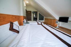 Ένα ή περισσότερα κρεβάτια σε δωμάτιο στο Quang Minh Dalat Hotel