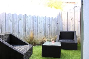 two chairs and a table in front of a fence at Fleur de Ré in Loix