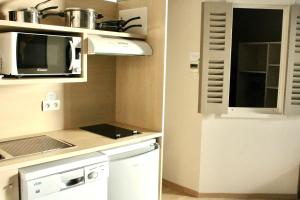 a small kitchen with a microwave and a stove at Fleur de Ré in Loix
