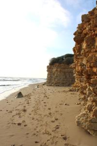 a stone wall on a beach next to the ocean at Fleur de Ré in Loix