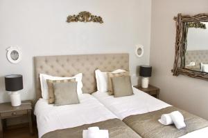 a bedroom with two beds and a mirror at Fleur de Ré in Loix