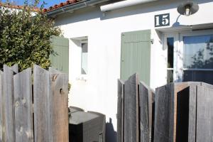a wooden fence in front of a house at Fleur de Ré in Loix