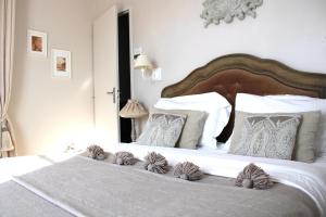 a bedroom with a large white bed with white pillows at Fleur de Ré in Loix