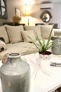a large glass vase sitting on a table with a plant at Fleur de Ré in Loix