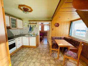 een kleine keuken met een tafel en stoelen in een kamer bij Ferienwohnung Sonnleiten in Puchberg am Schneeberg