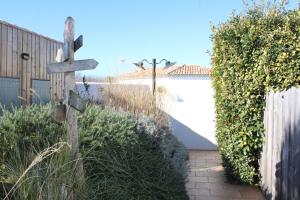 a wooden cross in a yard next to a fence at Fleur de Ré in Loix