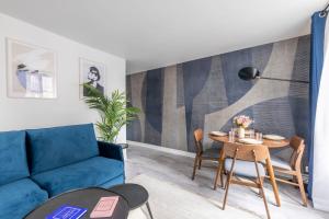 - un salon avec un canapé bleu et une table dans l'établissement Lovely and cosy apartment 4P1BR, à Paris