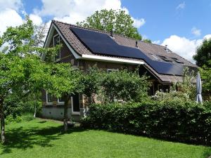 una casa con paneles solares en el techo en B&B Tulden Farmhouse, en Giethoorn