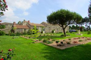 a garden in front of a building with a tree at Maison spacieuse proche du centre de Landevieille + jardin clôturé in Landevieille