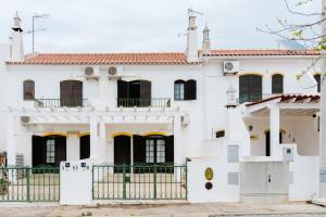 Biały dom z czarnymi oknami i bramą w obiekcie Altura Beach Villa by GT House w mieście Altura