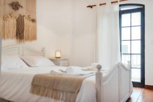 een slaapkamer met een wit bed en handdoeken bij Altura Beach Villa by GT House in Altura