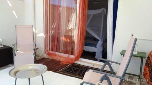 una camera con una sedia e una finestra con una tenda arancione di La Casina al Mare a Porto Cesareo
