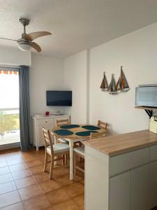 une cuisine et une salle à manger avec une table et des chaises dans l'établissement L’azur, au Lavandou