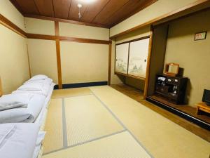Habitación con cama, TV y ventana. en Nagomi-Ryokan Yuu, en Kioto