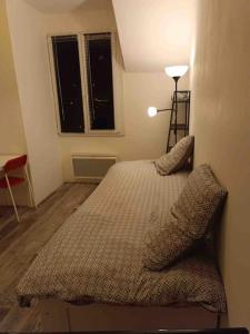 a bedroom with a bed and a lamp and a window at Studio au centre de Quimper 2ème ET in Quimper