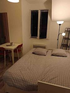 a bedroom with a bed and a table and a lamp at Studio au centre de Quimper 2ème ET in Quimper