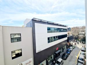 une vue aérienne d'un bâtiment avec des voitures garées sur un parking dans l'établissement G92 City Hotel, à Rhodes