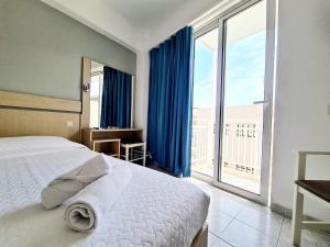 sypialnia z łóżkiem i dużym oknem w obiekcie G92 City Hotel w mieście Rodos
