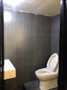 a bathroom with a white toilet and a sink at Rod Fai Fah Apartment in Bangkok