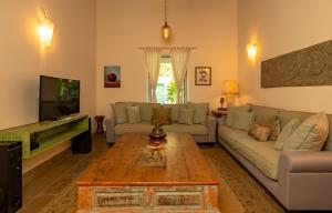 a living room with a couch and a coffee table at ama Stays & Trails 70 Vale, Goa in Vagator