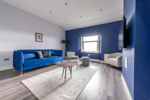 a living room with a blue couch and a table at Modern Complete Cotham House #2 by Prescott Apartments in Bristol
