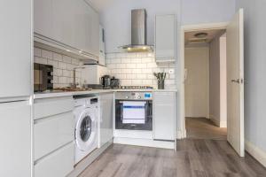 a white kitchen with a washer and dryer at Newly Renovated Cotham House #2 by Prescott Apartments in Bristol