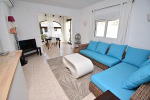a living room with blue couches and a table at Casa Capricho Javea - 5019 in Platja de l'Arenal