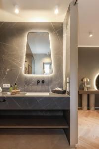 een badkamer met een wastafel en een spiegel bij Hotel Linger in Appiano sulla Strada del Vino