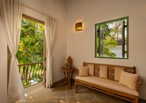 a living room with a couch and a window at ama Stays & Trails 70 Vale, Goa in Vagator