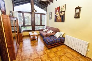 ein Wohnzimmer mit Sofa und Tisch in der Unterkunft Apartamentos el Caserón in Soto de Cangas