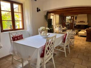 una sala da pranzo con tavolo e sedie bianchi di Magnifique villa en pierre au calme absolu a Fayence