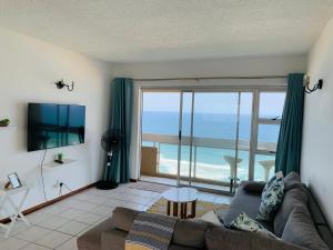 a living room with a couch and a view of the ocean at Serene Seascape Apartments in Amanzimtoti