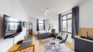 a living room with a couch and a television at SweetHome - Zentral - Küche & Parkplatz, WiFi in Halle an der Saale