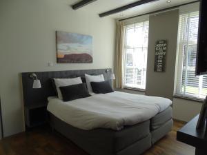 a bedroom with a large bed with white sheets and pillows at B&B Tulden Farmhouse in Giethoorn