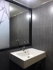 a bathroom with a sink and a mirror at Rod Fai Fah Apartment in Bangkok