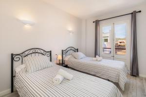 2 Betten in einem Schlafzimmer mit Balkon in der Unterkunft Apartamento Brisas in Port de Pollença