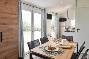 uma cozinha e sala de jantar com uma mesa de madeira e cadeiras em Camping Sites et Paysages Les Prés Hauts em Sisteron