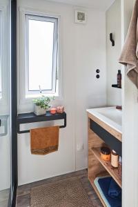 uma casa de banho com um lavatório e uma janela em Camping Sites et Paysages Les Prés Hauts em Sisteron