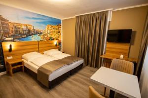 a hotel room with a bed and a painting of a city at Hotel Schlangenbader Hof in Schlangenbad