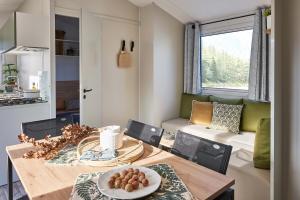 a kitchen and dining room with a table with a plate of food at Camping Sites et Paysages Les Prés Hauts in Sisteron