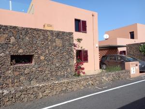 a stone wall in front of a house at Casa Livia Pool & Sunset in Corralejo