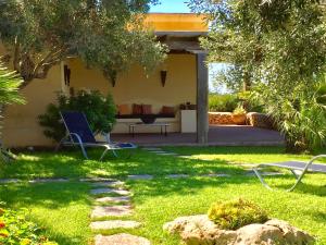 un patio con sofá y sillas en el césped en Cave Garden villa, en Favignana
