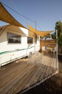 an rv with a table and a chair on a deck at Villaverde Glamping in Villaverde