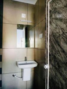 een badkamer met een wastafel en een spiegel bij The Lavender Resort Waynad in Vaduvanchal