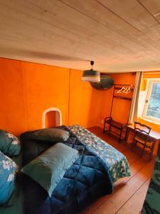 a bedroom with a couch in a room with orange walls at Ty Merzhin in Huelgoat