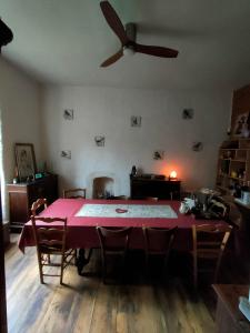 a dining room with a pink table and a ceiling fan at Ty Merzhin in Huelgoat