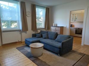 a living room with a blue couch and a table at Ferienwohnung Gasthof Port - a84059 in Naunheim