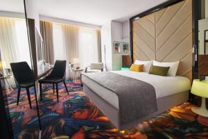 een hotelkamer met een groot bed en een bureau bij INX Design Hotel in Krakau