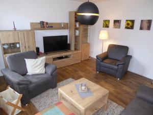 uma sala de estar com duas cadeiras e uma televisão em Wassermühle Stemmen em Kirchlinteln