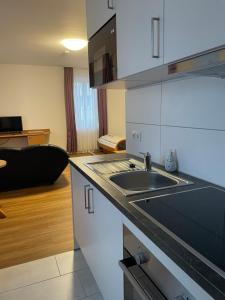 a kitchen with a sink and a living room at Apartment 4 in Braunsbach